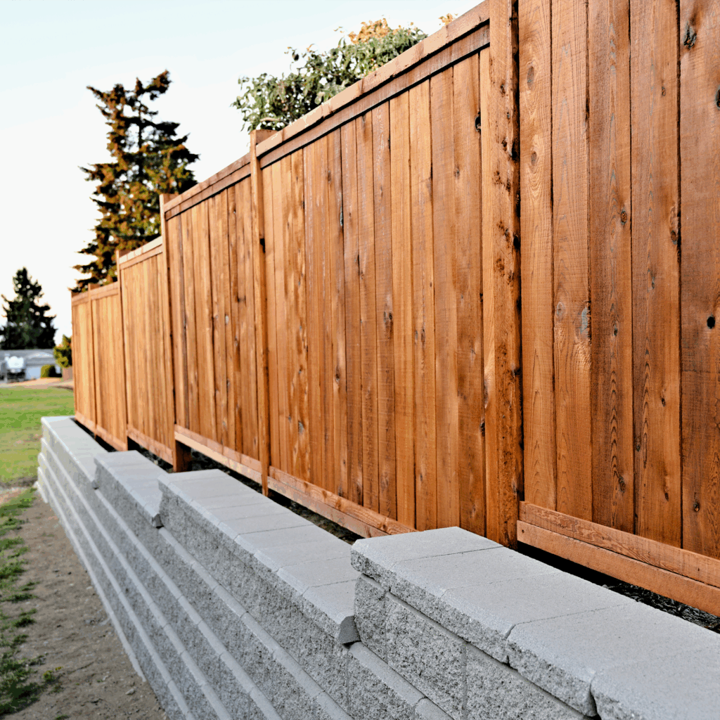 Custom wood privacy fence built on a concrete block retaining wall by Willamette Valley Landscape in Salem, Oregon.